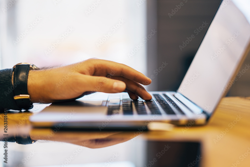 Poster sideview of man using devices on desk