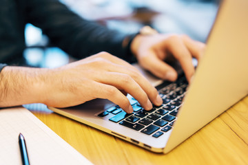 Sideview of man doing paperwork with laptop