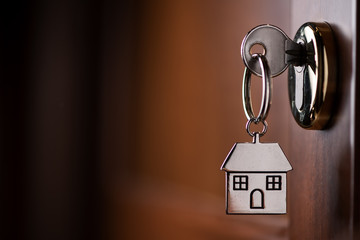 House key in the door. Symbol, chrome