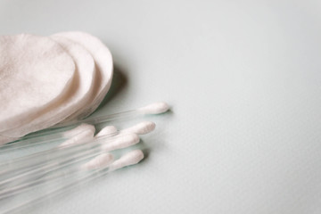 Remove cosmetic makeup cotton wool, women sanitary pads, plastic cotton pads, disposable sheet on light blue background. Health and hygiene products. Selective soft focus, text copy space.