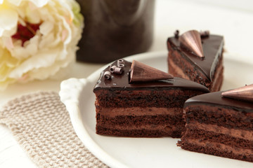Chocolate cake slice with curl on white background