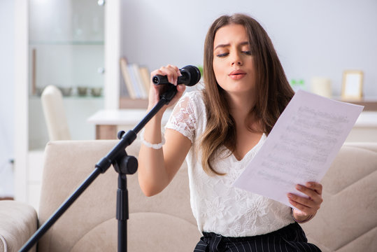 Female beautiful musician singing at home