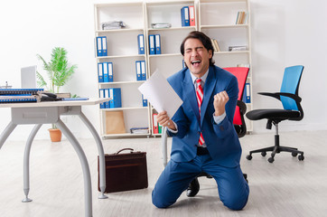 Young happy male employee in the office 