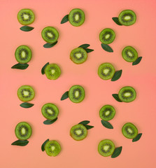 Colorful fruit pattern of fresh kiwi slices on pink background. From top view