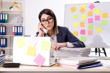 Young female employee in conflicting priorities concept 