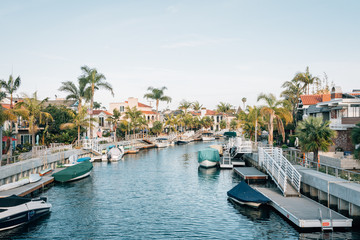 Fototapeta na wymiar Boats and houses along a canal in Naples, Long Beach, California