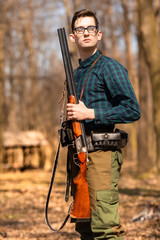 Autumn hunting season. Man hunter with a gun. Hunting in the woods