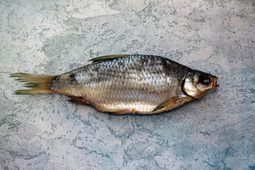 dried dried golden fish, river fish, lies on a gray table