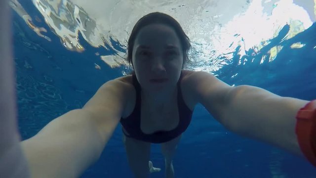 girl in bathing suit swimming under water gopro pool