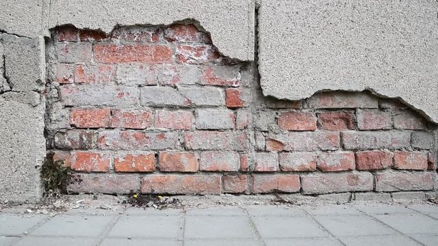 Bad foundation base on old house or building cracked plaster facade wall with brick background