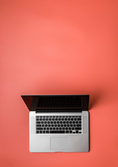 Fototapeta na wymiar Laptop on pastel red blank background