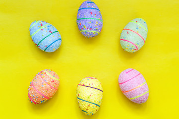 Handmade Easter eggs on a yellow background. Space for text.