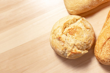 Assortment, different kind of wheat baked bread with golden crust on wooden table background with copy space