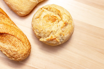 Assortment, different kind of wheat baked bread with golden crust on wooden table background with copy space