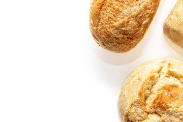 Assortment, different kinds of wheat baked bread with golden crust on white background with copy space, bakery and grocery concept