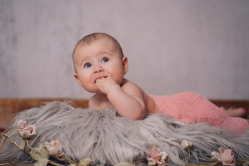 Portrait Baby offene Augen mit Hand im Mund schaut in Kamera soft tones