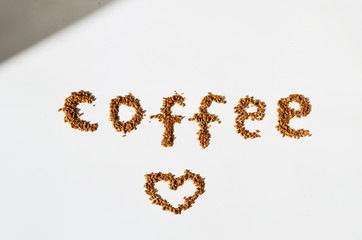 Granulated instant coffee in a shape of text and a heart on a white background,photo