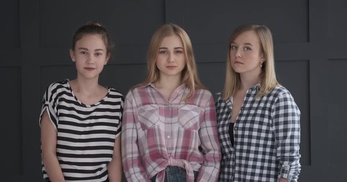 Three teenage girls shaking head in denial