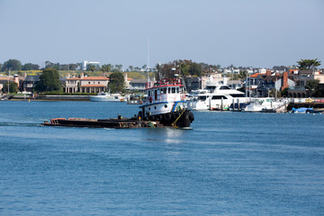 Fototapeta premium Tugboat moves through the water of the bay