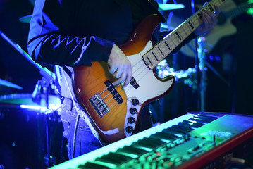 Obraz premium Man playing guitar at music concert during night .