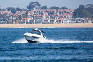 Obraz premium Speedboat cuts through the water of the bay
