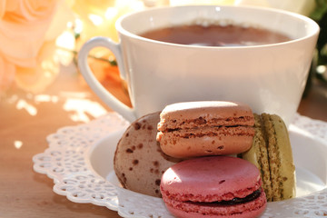Fresh macaroons with tea on a light background. Extremely shallow depth of field with selective focus in the foreground.