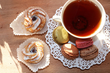 Fresh macaroons with tea on a light background. Extremely shallow depth of field with selective focus in the foreground.