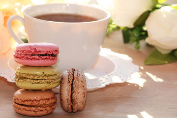 Fresh macaroons with tea on a light background. Extremely shallow depth of field with selective focus in the foreground.