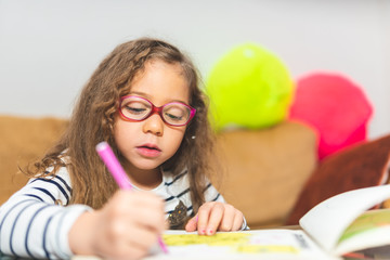 Little Girl Drawing on a Notebook.