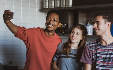 Happy friends taking selfie indoors