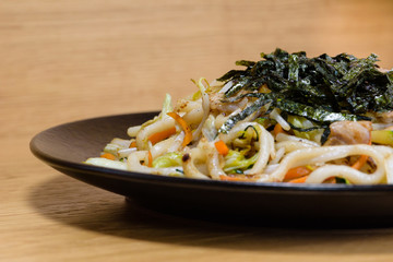 noodles with grilled vegetables and fried seaweed, grilled pork, carrots and soybean sprouts