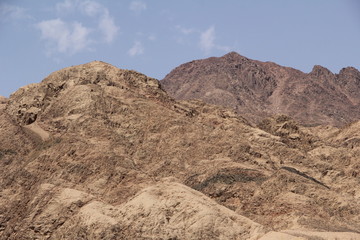 desert mountains lit by the sun against the blue sky