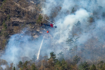 Obraz premium Helicopter extinguishing wildfire. Bergen, Norway.