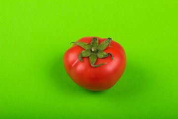 red tomato on green background