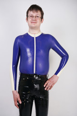 Caucasian nerd chubby man dressed in fashionable latex rubber fetish clothes on white background in...
