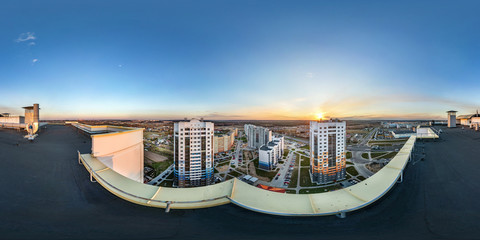 Aerial full seamless spherical panorama 360 angle degrees view from roof of multi-storey building with view of residential quarter on sunset in equirectangular projection.