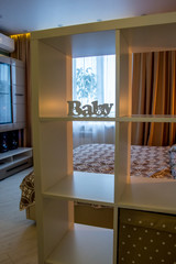 Modern home interior living room decor elements and segments of luxury furnishings of an empty apartment with a square rack and white baby lettering