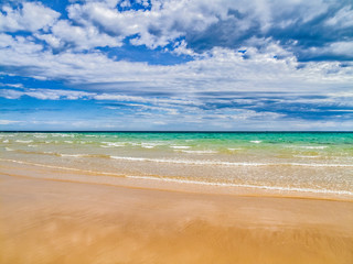 Fototapeta na wymiar Clouds rolling in over a deserted tropical sandy beach