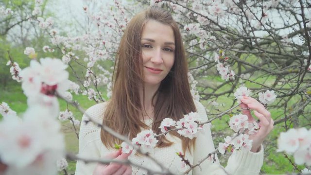 Beautiful girl near blossoming tree in spring