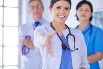 Fototapeta premium Female doctor offering a handshake in the hospital