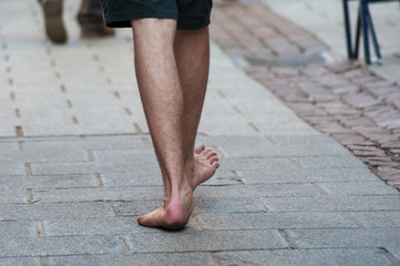 closeup of hippie man walking on the road without shoes