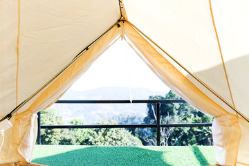 View from the canvas tent upon the green meadow with trees © suwatwongkham