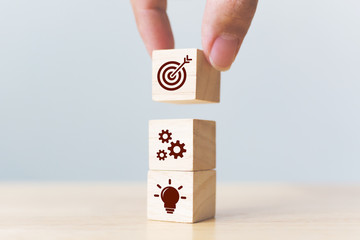 Concept of business strategy and action plan. Businessman hand putting wood cube block on top with...