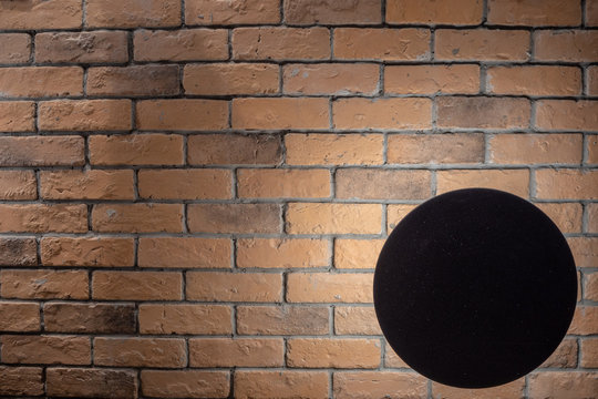 Black lamp with light on orange brick wall for background and copy space © Akara