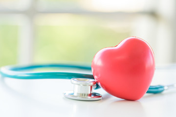 Red heart and stethoscope with window background in the morning.
