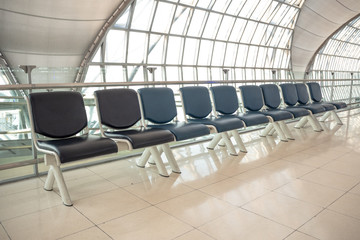 Empty row of black seat for waiting at the gate in the airport