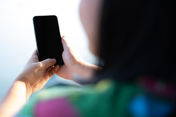 woman's hand holding and using smartphone, black screen with blur background. subject is blur.