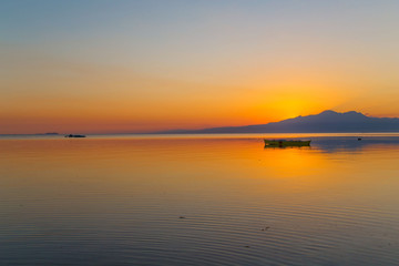 outrigger fisher boat at the sea shore in a long expose photography and a white sand tropical beach, a tranquil summer sunset dusk background scene