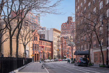 A corner of Greenwich Ave in New York's Greenwich Village with iconic brick buildings and cars...
