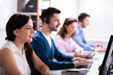 Smiling Customer Service Executives Using Earphones